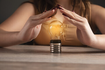 Woman hands protecting a light bulb