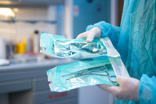 Close up of dentist hands in white sterile gloves holding dental