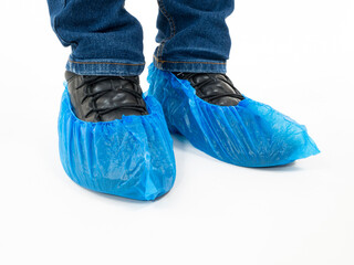 Blue medical shoe covers are worn over shoes on white background,  hygiene and cleanliness in medical institutions.