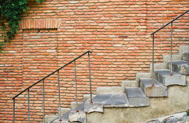 Stairs on the background of a brick wall, the streets of the old city, the idea for a screensaver or an article about travel and a comfortable urban environment. Free space