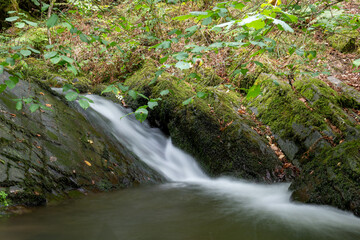 Long exposure of a waterfall on the Horner Water river in Horner woods in Somerset