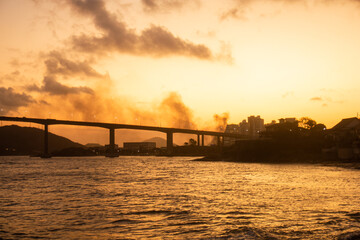 Fototapeta na wymiar terceira ponte de Vitoria ao atardecer com o mar e o ceu amarelos 