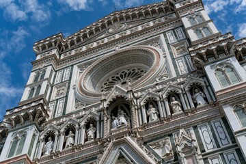 Low angle of the Florence Cathedral in Italy with a cloudy blue sky in the background.