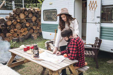 Young beautiful loving couple travelling across country in the van. Millennial man and woman in a...