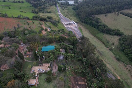 Aerial image of the Romildo Prado highway and its toll booths. Road with vegetation around it and car traffic.
