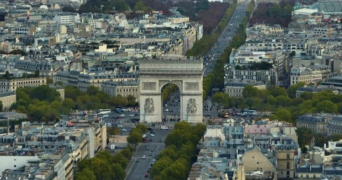 Aerial drone view Triumphal Arch of the Star famous landmark and tourist attraction at sunrise. Above Traffic on the street on a sunny morning under clear blue sky