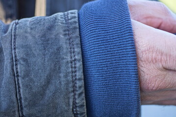 part one hand in blue sleeve sweater and gray jacket