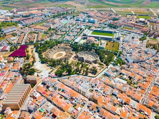 Aerial view of ruins of antique Roman amphitheatre and Theatre on background of modern Merida cityscape, Spain - obrazy, fototapety, plakaty