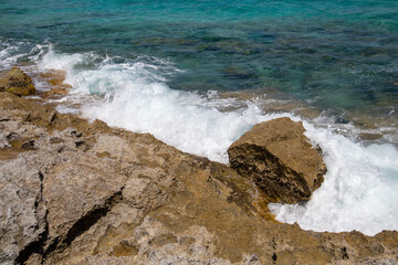Rocky beach with a turquoise blue sea and waves in spain