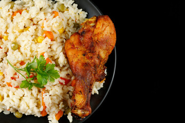 Fried chicken and rice with vegetables in a plate. A tasty and hearty dish.