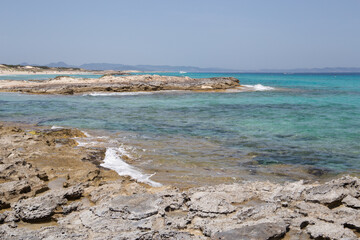 Rocky beach with a turquoise blue sea and waves in spain