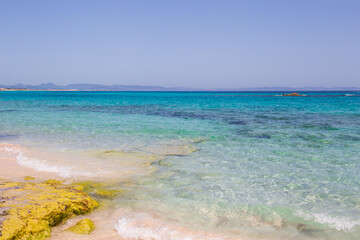 Rocky beach with a turquoise blue sea and waves in spain