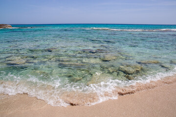Rocky beach with a turquoise blue sea and waves in spain
