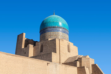 Tower with the ceramic turquoise dome of the Kalyan Mosque in Bukhara