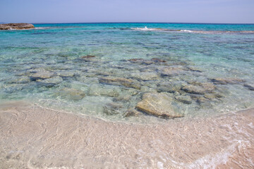 Rocky beach with a turquoise blue sea and waves in spain