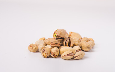 Pile of pistachios in the peel close-up on a white background. Isolated.
