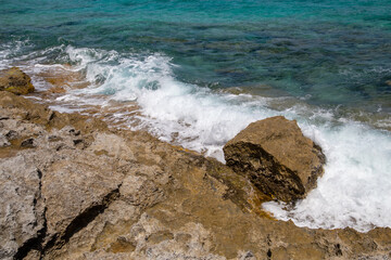 Rocky beach with a turquoise blue sea and waves in spain