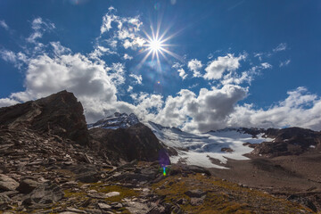 Sunny panorama of Barba d'Orso Glacier dominated by snow capped peaks. The glacier is in rapid retreat caused by global warming, Alto Adige, Italy. Popular mountain with climbers