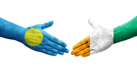 Handshake between Ivory Coast and Palau flags painted on hands, isolated transparent image.
