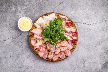 assorted sausage cuts on a wooden board on a gray background in a restaurant