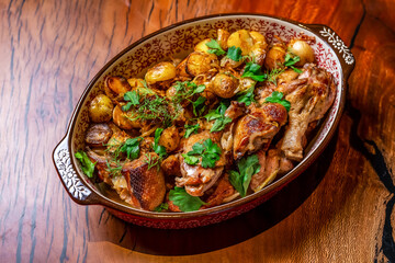 dish chicken drumsticks baked with potatoes on a dish in a restaurant