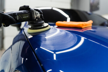 Hard wax car polishing with orbital polisher for remove scratches close-up. Working process in...