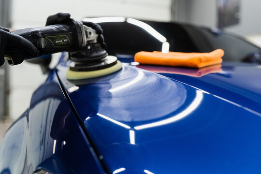 Hard wax car polishing with orbital polisher for remove scratches close-up. Working process in detailing auto service.