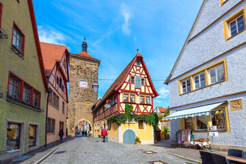 Fototapeta na wymiar Picturesque half-timbered buildings alongside the Siebersturm city gate in the historic medieval old town of Rothenburg ob der Tauber, Germany.
