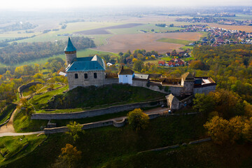 Picturesque autumn landscape with imposing historic Kuneticka Hora Castle on hilltop above Czech...