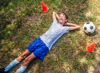 Child Youth Boy Soccer Player Laying on the Ground Wet