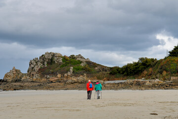 Couple de randonneurs qui marche sur une plage en Bretagne