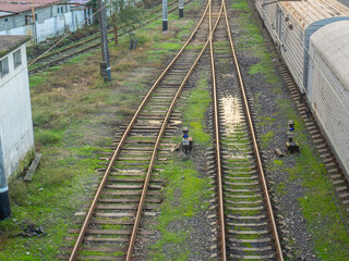 Fototapeta na wymiar Rails with sleepers on top. Puddles between the rails. Abandoned place. Old station. Cargo transportation. industrial zone