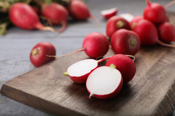 Fresh ripe radishes on grey wooden table, closeup. Space for text