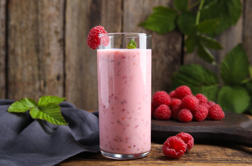 Glass of tasty fresh raspberry smoothie on wooden table