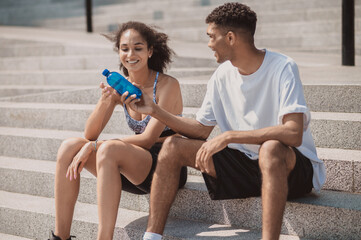 Two young people resting after workout and looking relaxed