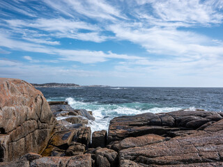 Fototapeta na wymiar The ocean hits the rocks at Peggy's Cove in Halifax