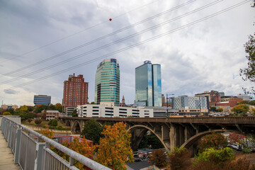 glass skyscrapers and office buildings in the city skyline with autumn colored trees and lush green trees on a cloudy day in Knoxville Tennessee USA - obrazy, fototapety, plakaty