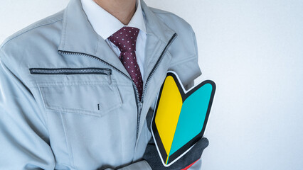 日本の初心者マークと作業服の男性