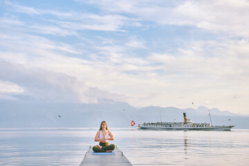 Geneva lake landscape, woman practicing yoga on dock, steam boat floating on background