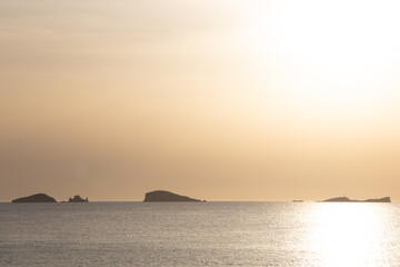 Sunset on the island of Ibiza with the sun setting on the horizon and orange colors in the sky