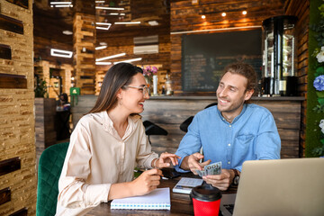 Young business owners working at table in their cafe