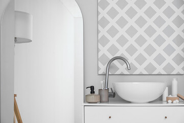 Big mirror, modern sink and bath accessories near white wall in bathroom