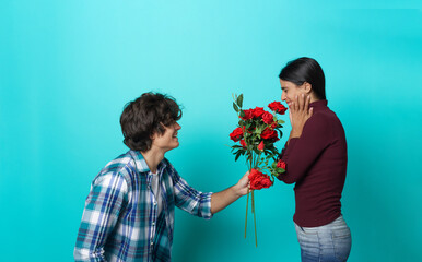Boyfriend asking girlfriend out on a date with a bouquet of roses, beautiful red flowers; excited...