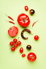 Composition with fresh tomatoes and dried chili peppers on green background