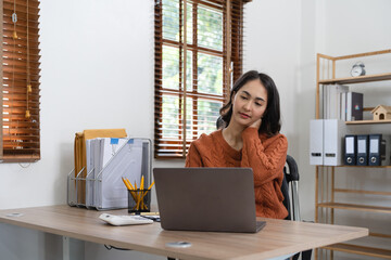 business Asian woman having neck pain while working on computer laptop. office syndrome concept.