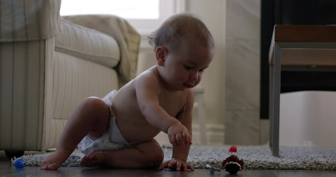 Baby girl drooling while sitting and playing on living room floor