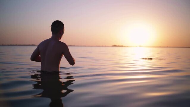 young man throws a pebble into the water