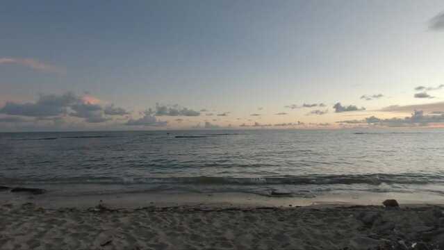 Toma de un agradable atardecer en una playa de arena de una isla tropical