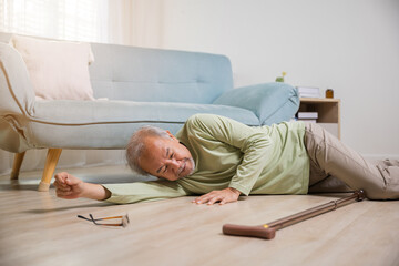 Asian old man lying on floor after falling down with wooden walking stick, Sick senior man beside...