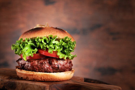 Homemade hamburger with large beef cutlet and fresh vegetables